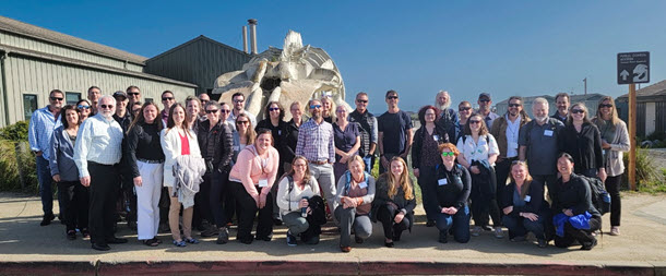 Summit Attendees in front of a blue whale skeleton